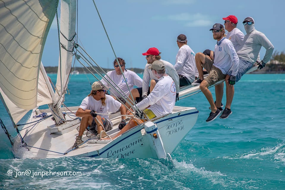 Sailors hiking out on a racing sailboat at the National Family Islands Regatta in Great Exuma Bahamas